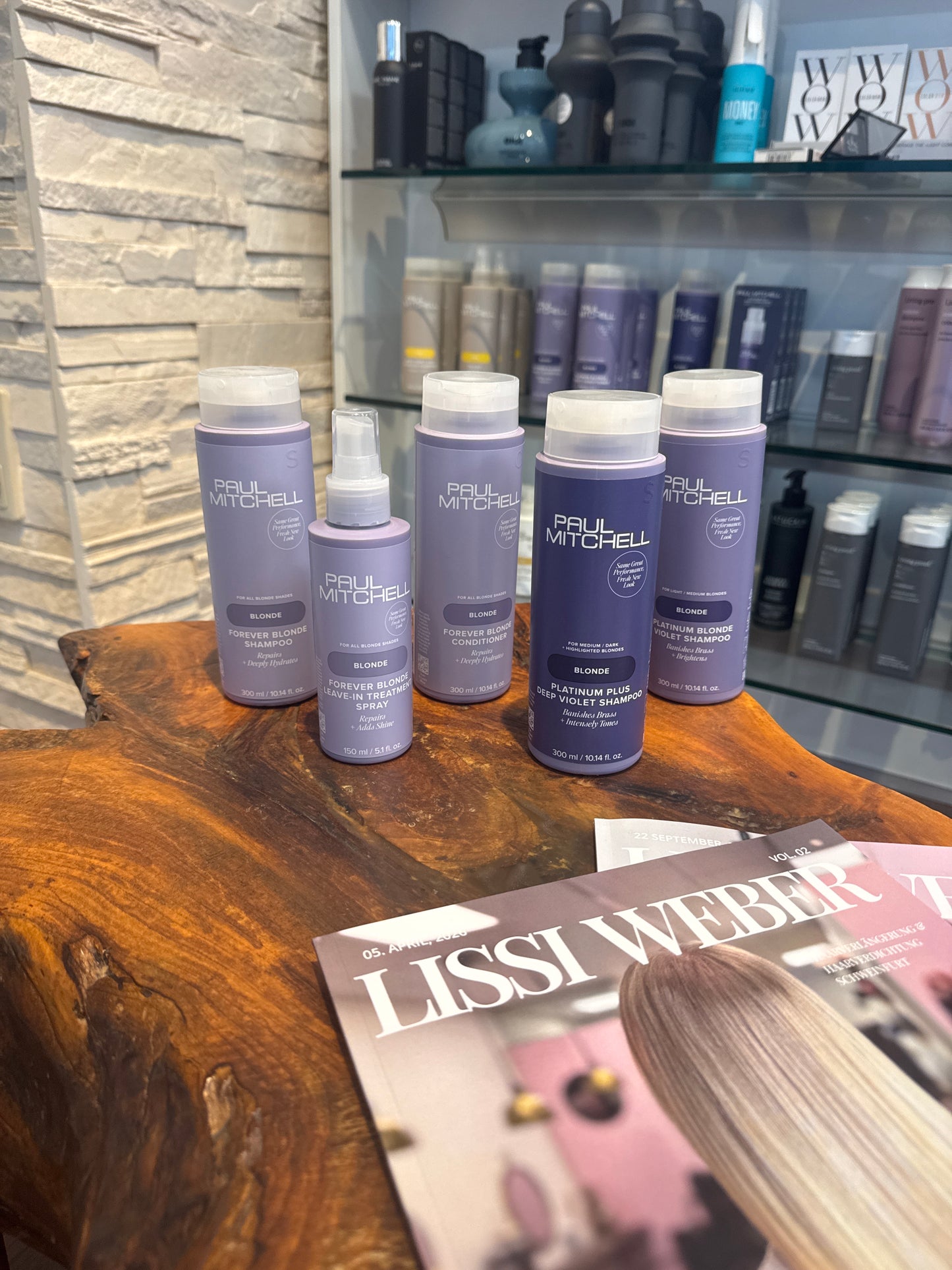 Blonde Shampoo Conditioner Leave-in Spray und Silbershampoo für blondes Haar im Set auf Holztisch – Paul Mitchell