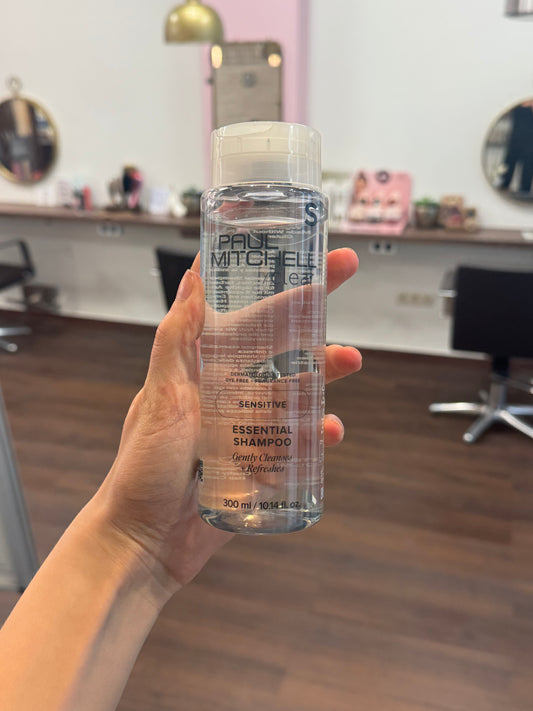 Paul Mitchell Clear Essential Shampoo sensitiv mildes Shampoo für empfindliche Kopfhaut, transparente Flasche in Hand im Salon – Paul Mitchell
