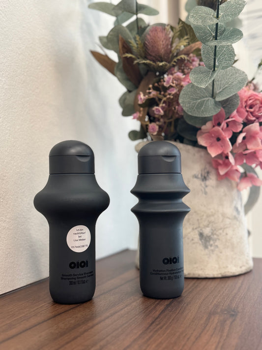 QiQi Smooth Service Shampoo und Hydration Fixation Conditioner nebeneinander auf hellem Hintergrund QiQi
