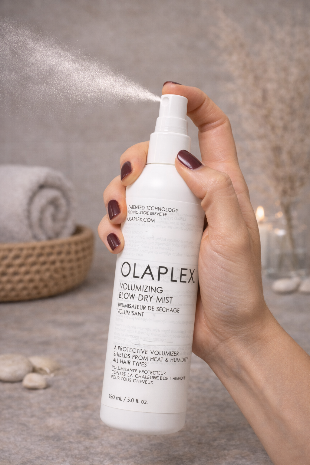 Olaplex Volumizing Blow Dry Mist Sprayflasche ohne Kappe beim Sprühen, Hand hält Produkt – Olaplex