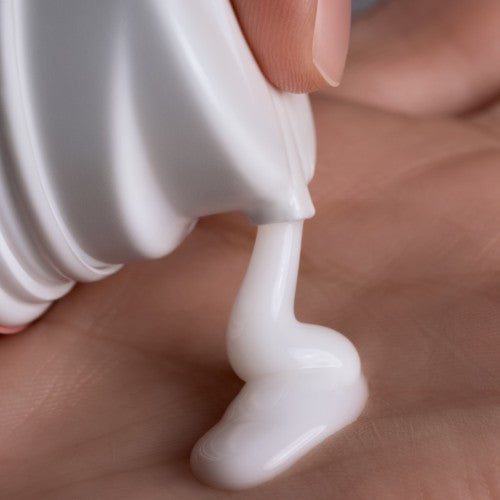 Living Proof Curl Definer cremige Styling Textur wird aus Spender in die Hand dosiert – Living Proof