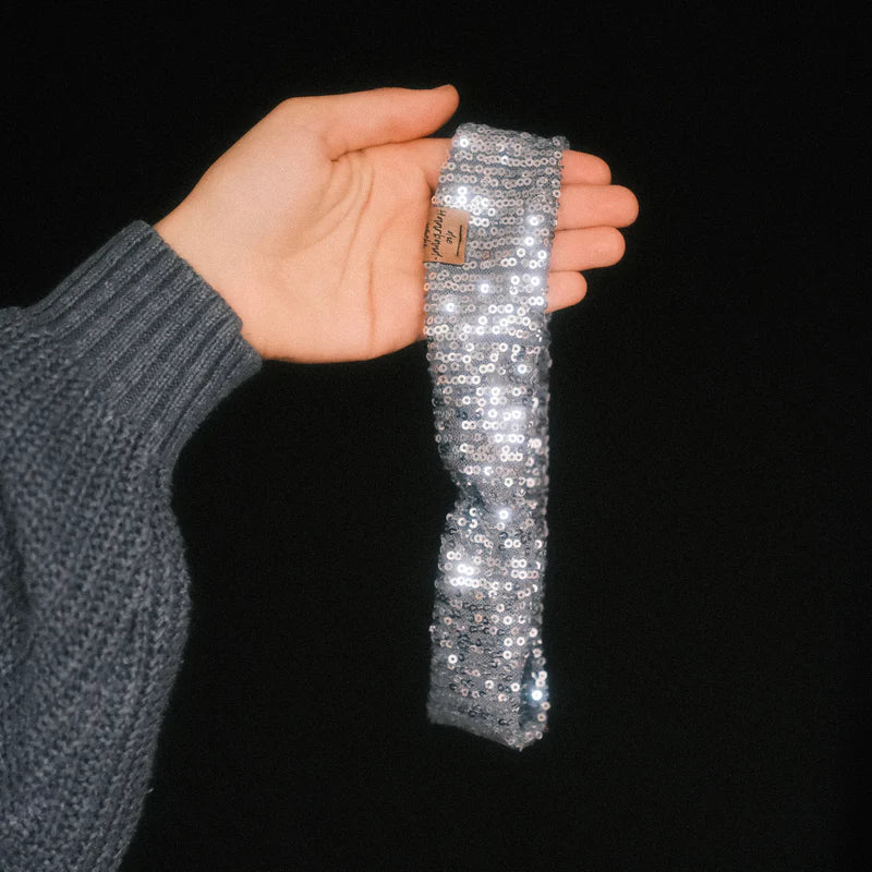 Basic Haarband Pailletten Silberglanz in der Hand gehalten mit schimmerndem Stoff dieHaarbanduschi