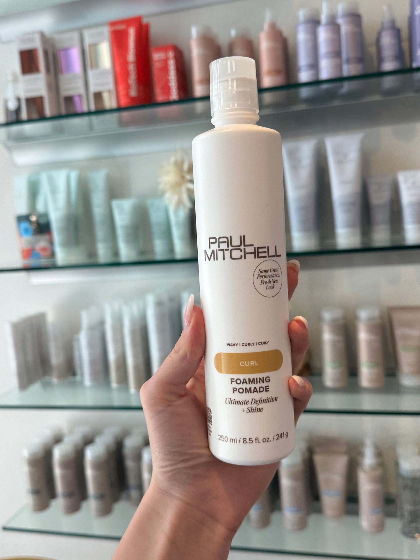 Paul Mitchell Curl Foaming Pomade – Lockenschaum für Definition und Glanz in der Hand im Friseursalon fotografiert – Paul Mitchell