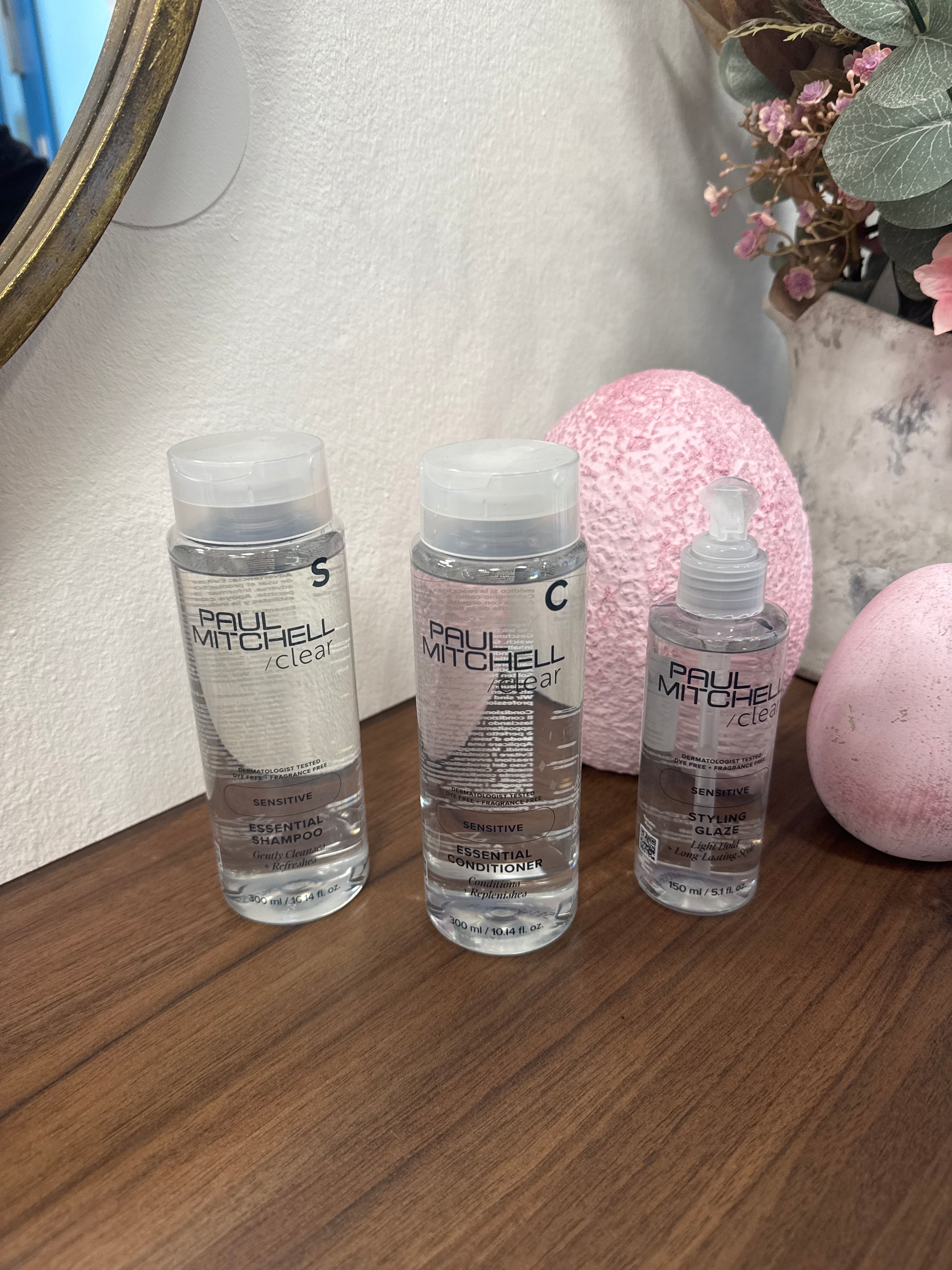 Sensitive Shampoo Conditioner Styling Glaze für empfindliche Kopfhaut drei Produkte auf Holztisch – Paul Mitchell