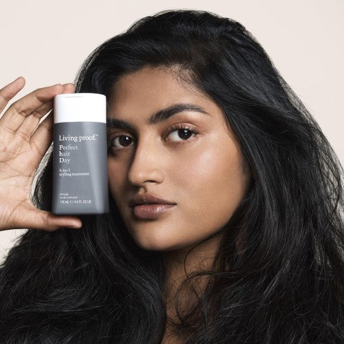 Living Proof Perfect Hair Day 5 in 1 Styling Treatment Model mit Produktflasche in der Hand Lifestyle Aufnahme – Living Proof