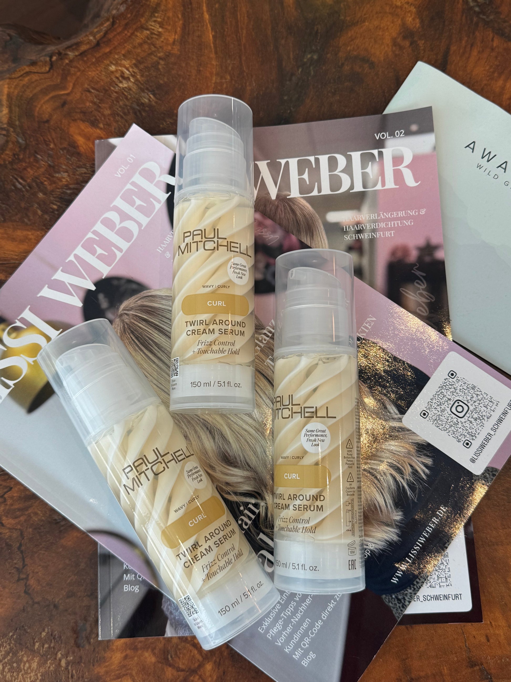 Paul Mitchell Curl Twirl Around Cream Serum – Drei Lockenseren als Flatlay auf Magazinen und Holztisch fotografiert – Paul Mitchell