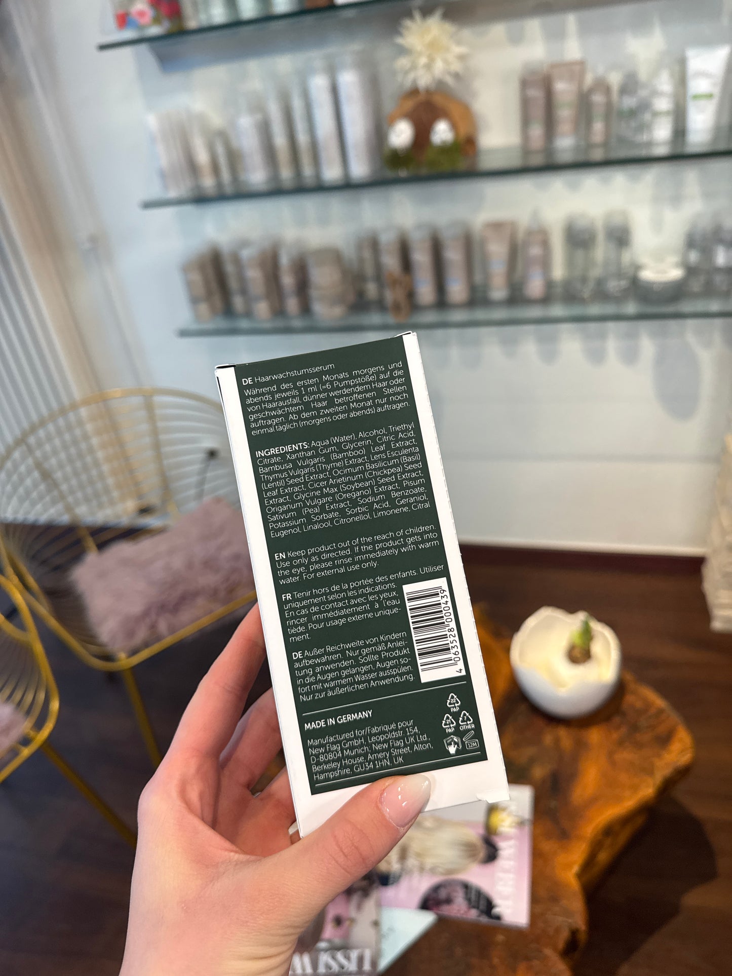 Haarserum Inhaltsstoffe Rückseite Verpackung Nahaufnahme in Hand im Salonumfeld – Natucain