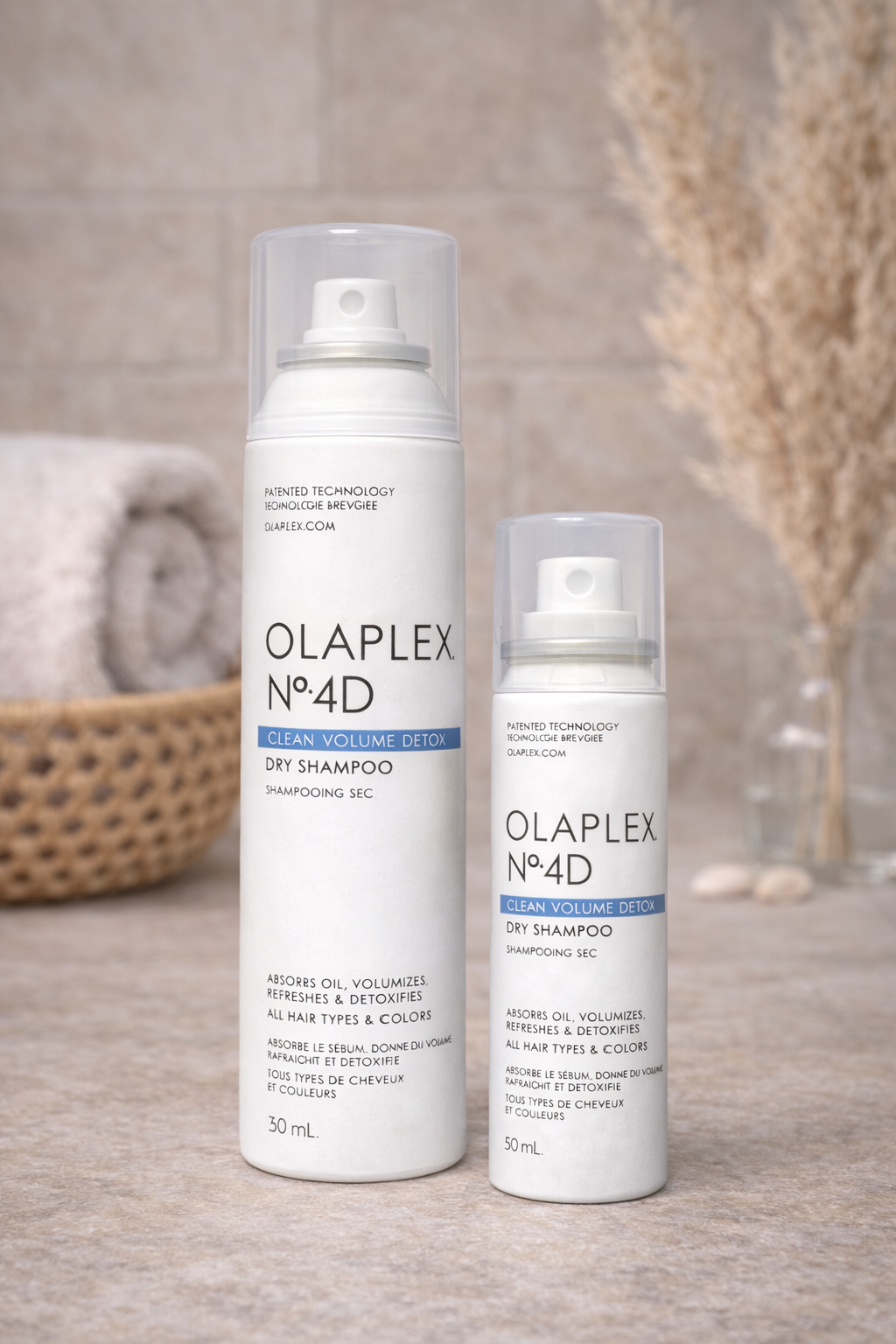 Olaplex No.4D Clean Volume Detox Dry Shampoo in Originalgröße und Reisegröße, zwei Sprayflaschen nebeneinander auf hellem Hintergrund – Olaplex