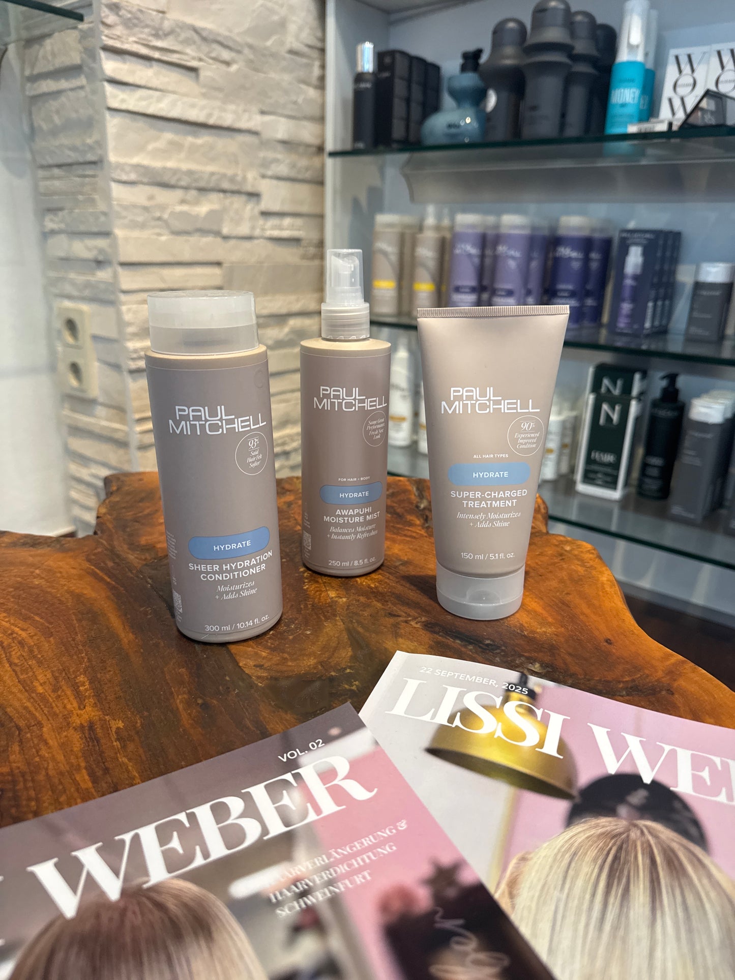 Hydrate Conditioner Feuchtigkeitsspray und Intensivkur für trockenes Haar auf Holztisch im Salon – Paul Mitchell