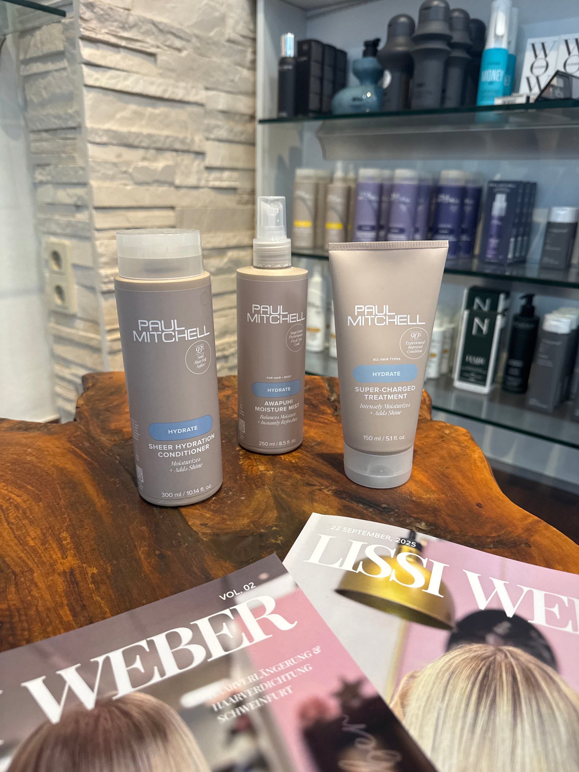 Hydrate Conditioner Feuchtigkeitsspray und Intensivkur für trockenes Haar auf Holztisch im Salon – Paul Mitchell