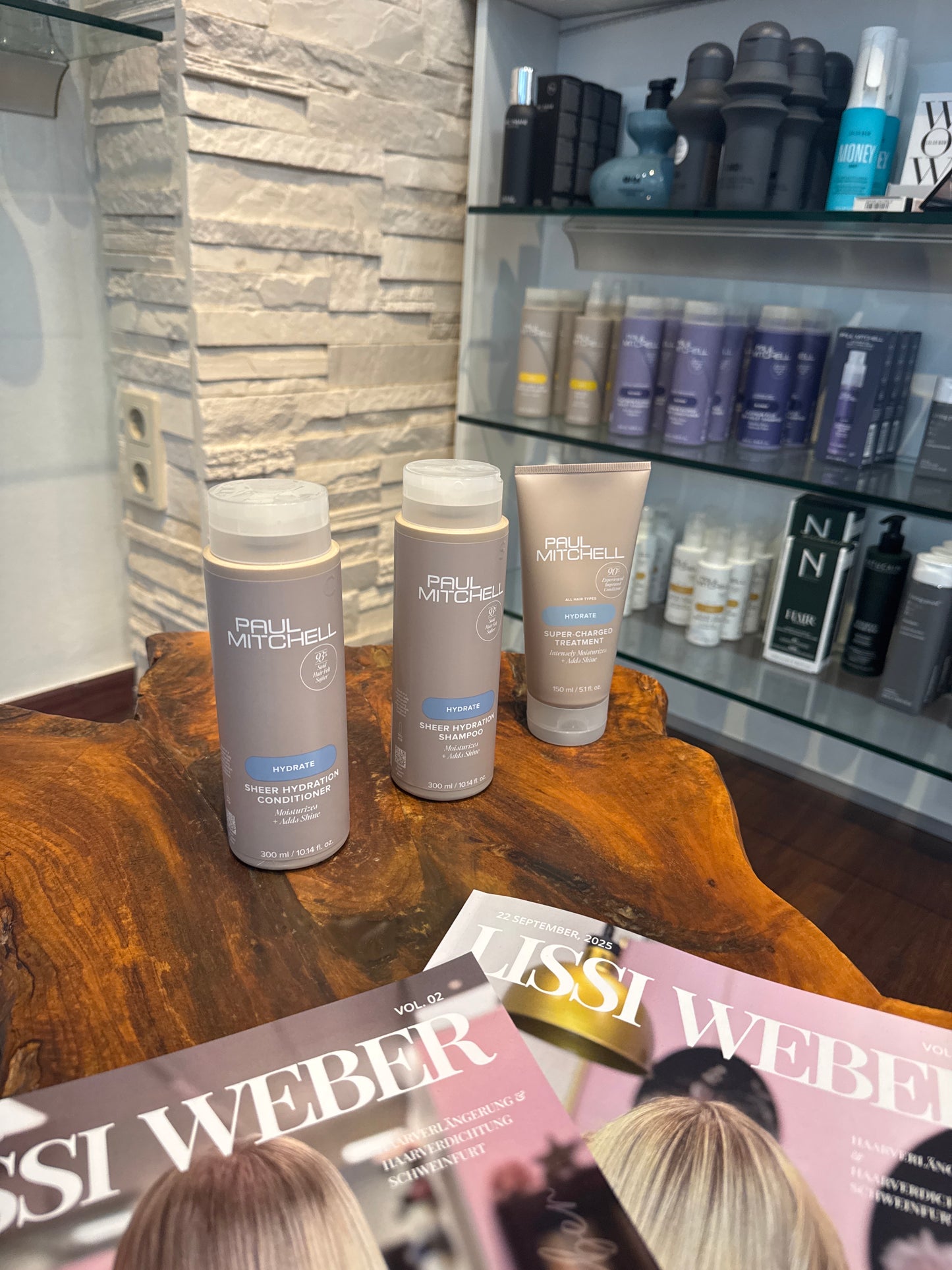 Hydrate Shampoo Conditioner und Intensivkur für trockenes Haar im Set auf Holztisch im Salon – Paul Mitchell