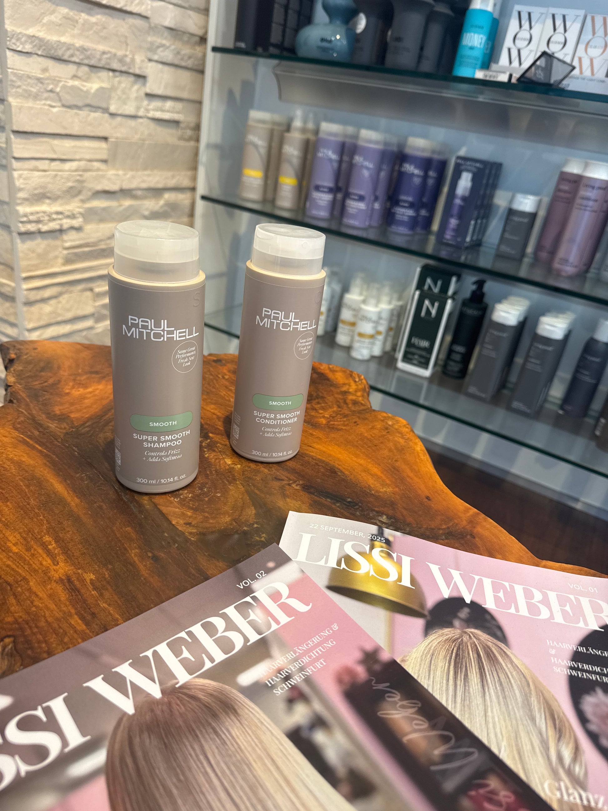 Super Smooth Shampoo und Conditioner für glattes frizzfreies Haar im Set auf Holztisch im Salon – Paul Mitchell