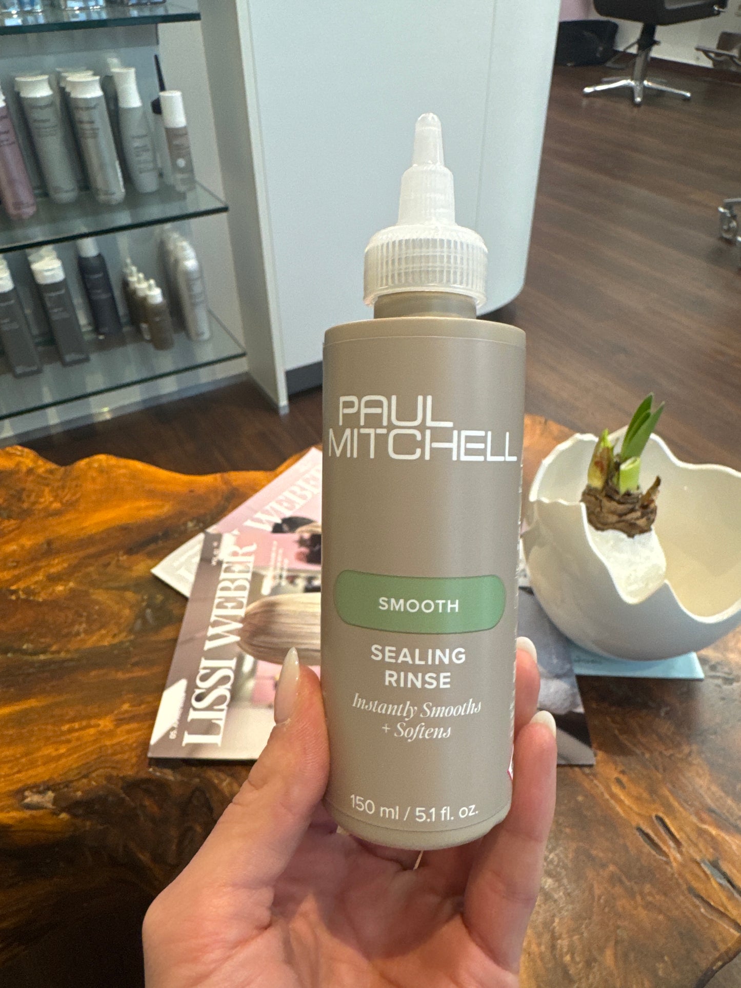 Sealing Rinse Glanzpflege für glattes frizzfreies Haar in Hand im Salonbereich – Paul Mitchell