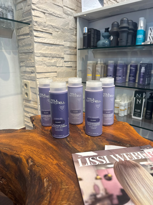 Silbershampoo und Blonde Shampoo für blondes Haar gegen Gelbstich im Set auf Holztisch – Paul Mitchell