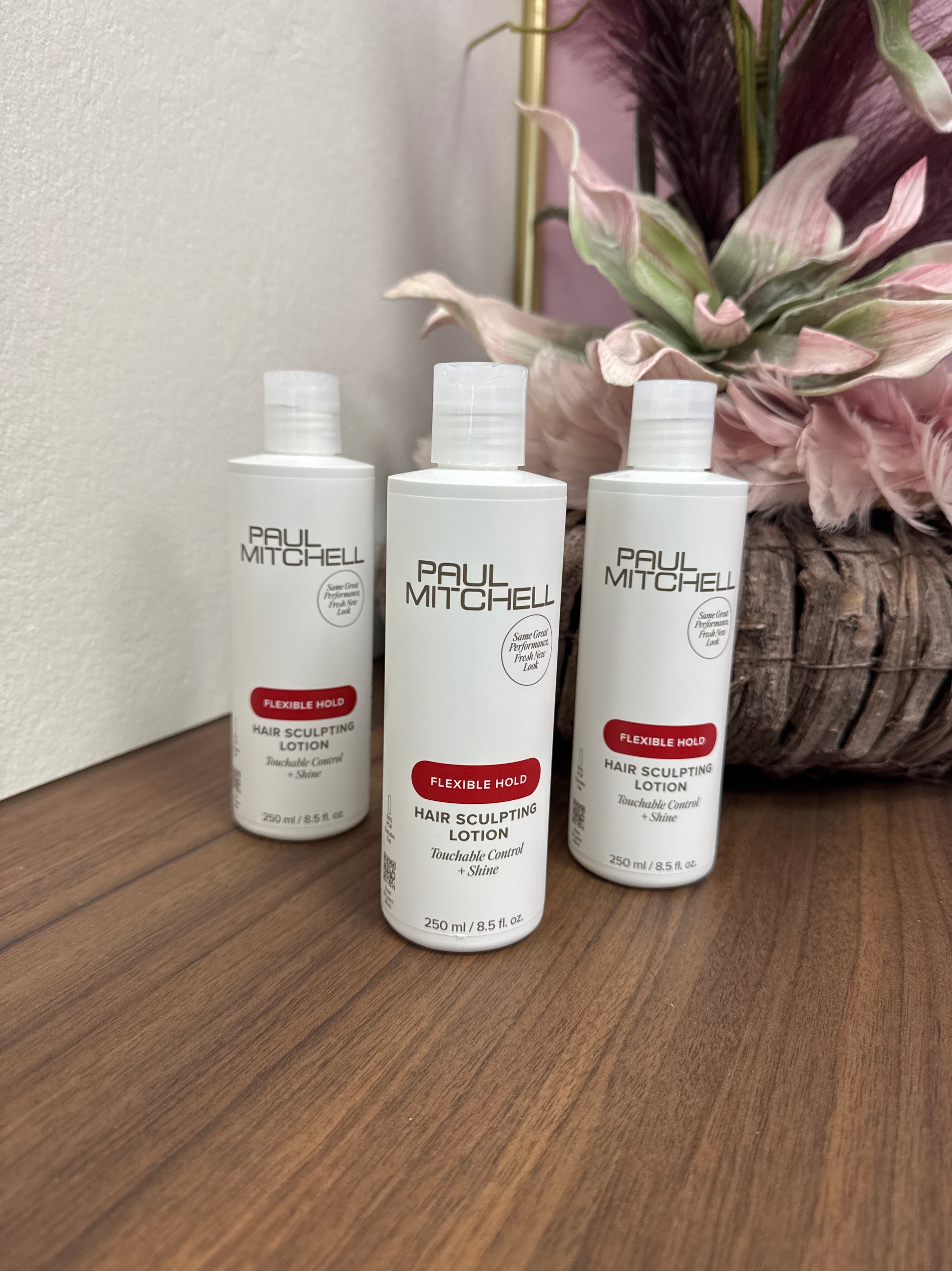 Stylinglotion flexibel Halt Paul Mitchell Hair Sculpting Lotion mehrere Flaschen auf Holztisch Paul Mitchell