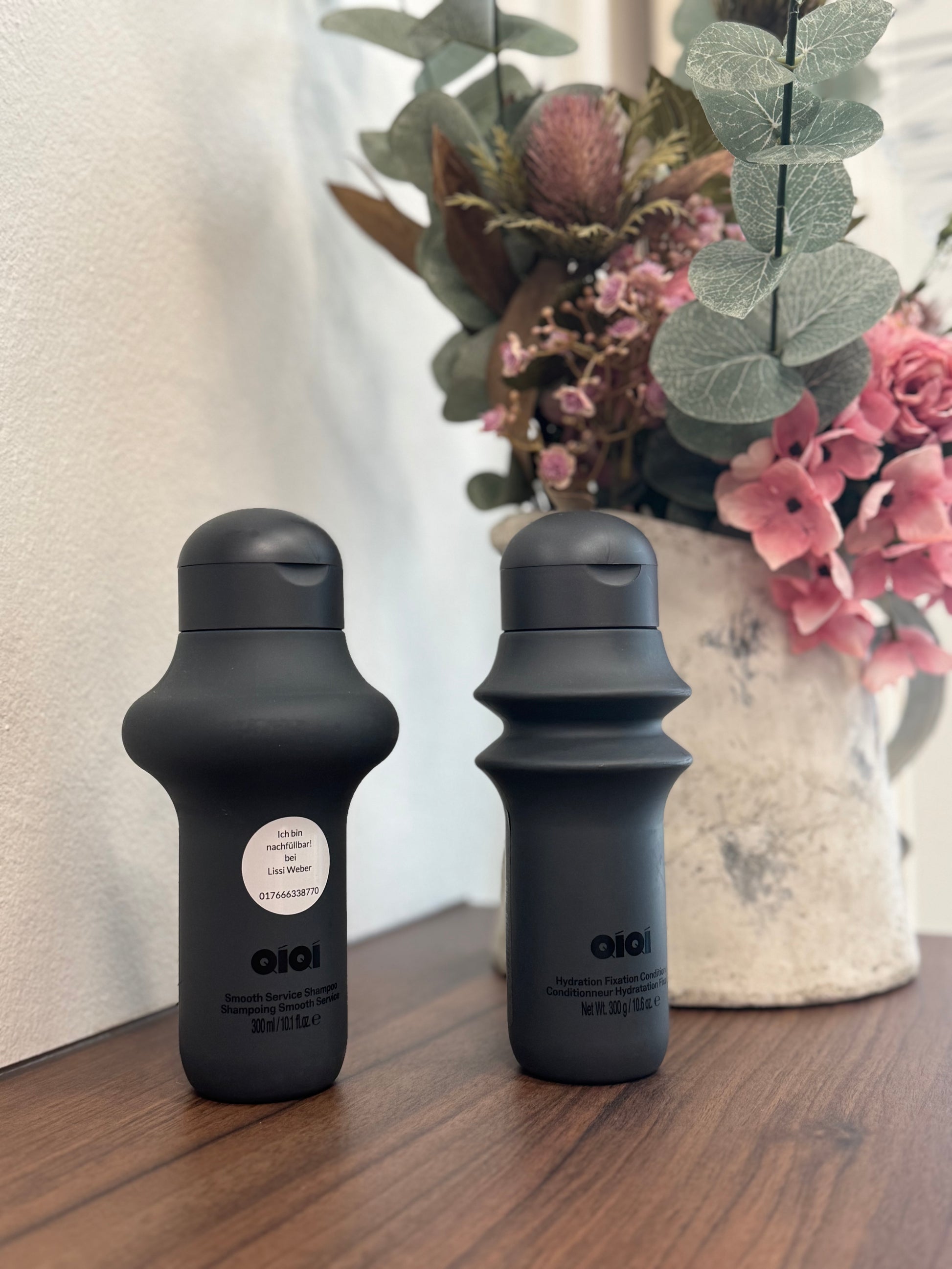 QiQi Smooth Service Shampoo und Hydration Fixation Conditioner nebeneinander auf hellem Hintergrund QiQi