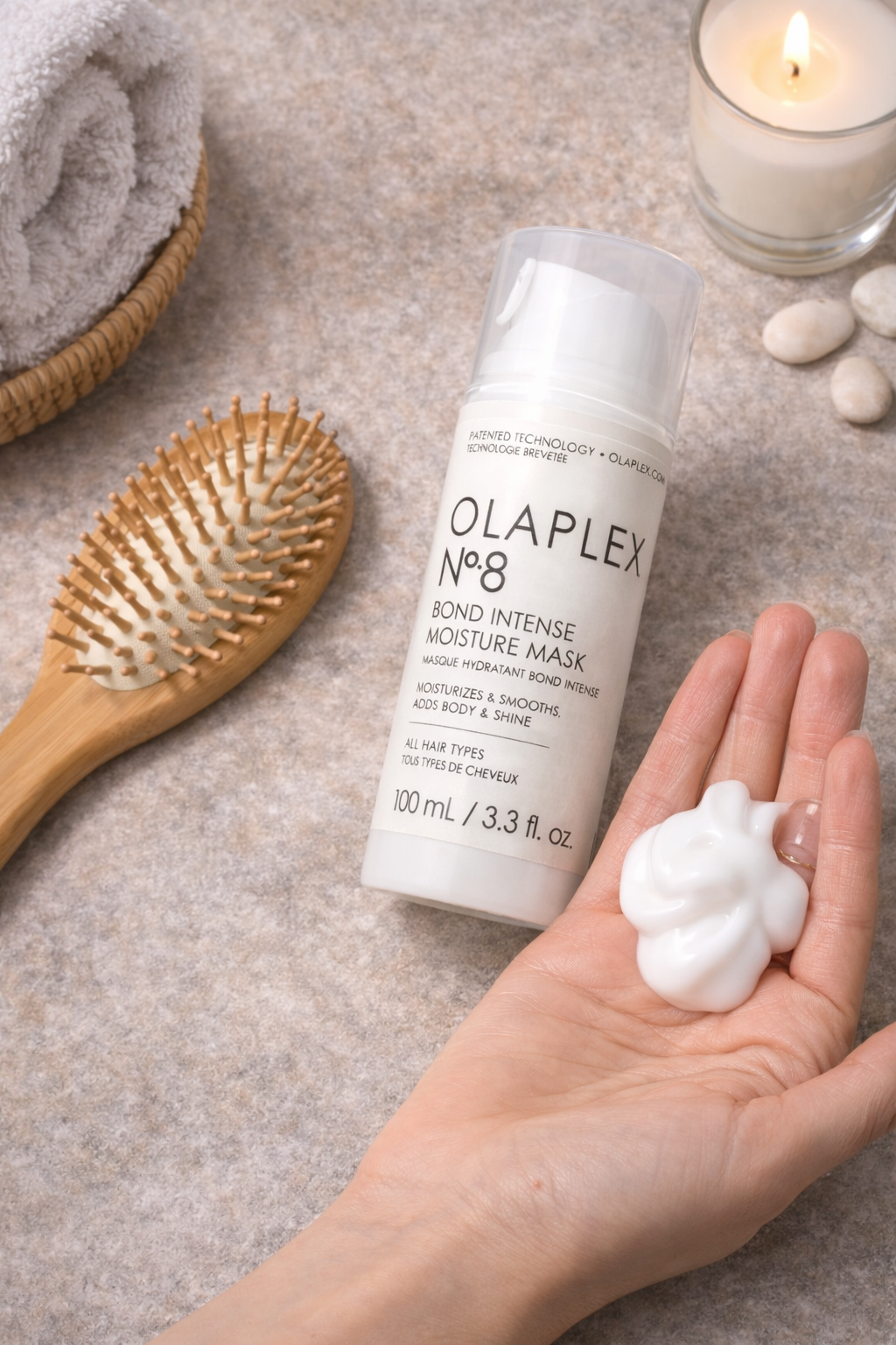 Olaplex No.8 Bond Intense Moisture Mask pflegende Haarmaske, Produkt mit Hand und Styling Accessoires im Lifestyle Setting – Olaplex