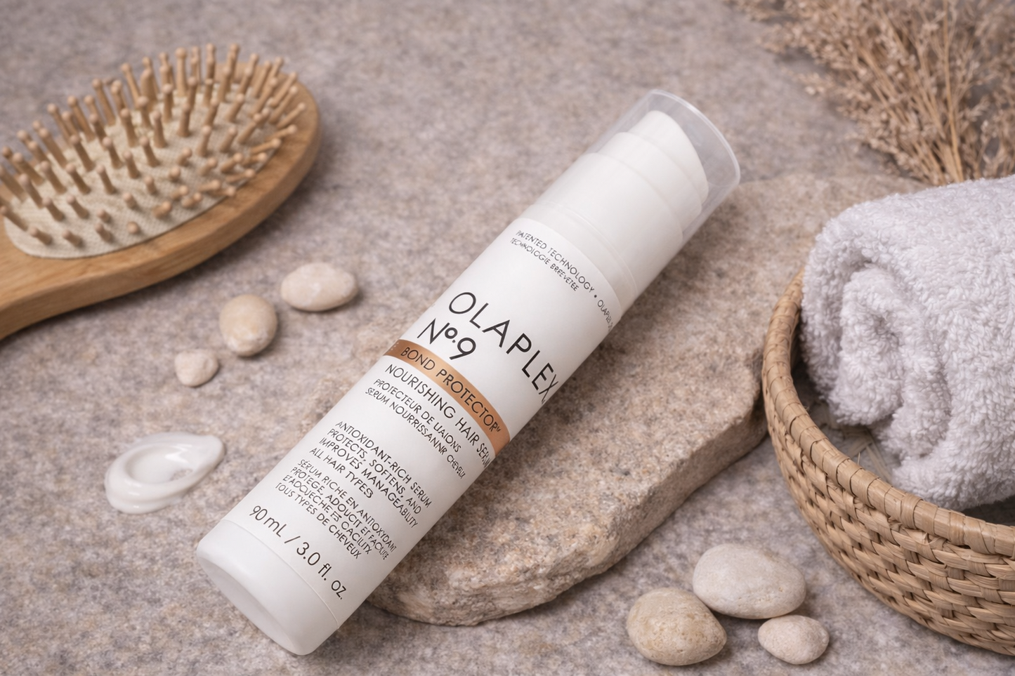 Olaplex No.9 Bond Protector Serum Flasche liegend mit passenden Accessoires in natürlicher Anordnung – Olaplex