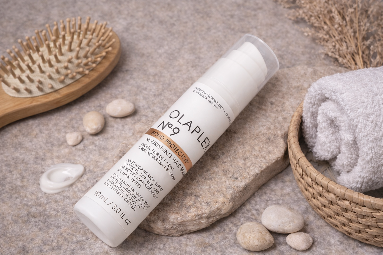 Olaplex No.9 Bond Protector Serum Flasche liegend mit passenden Accessoires in natürlicher Anordnung – Olaplex