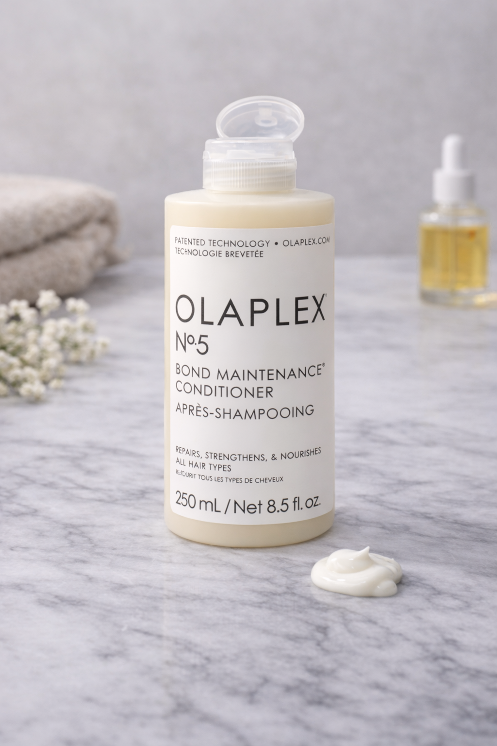Olaplex No.5 Bond Maintenance Conditioner pflegende Haarspülung, Produktflasche in der Hand – Olaplex
