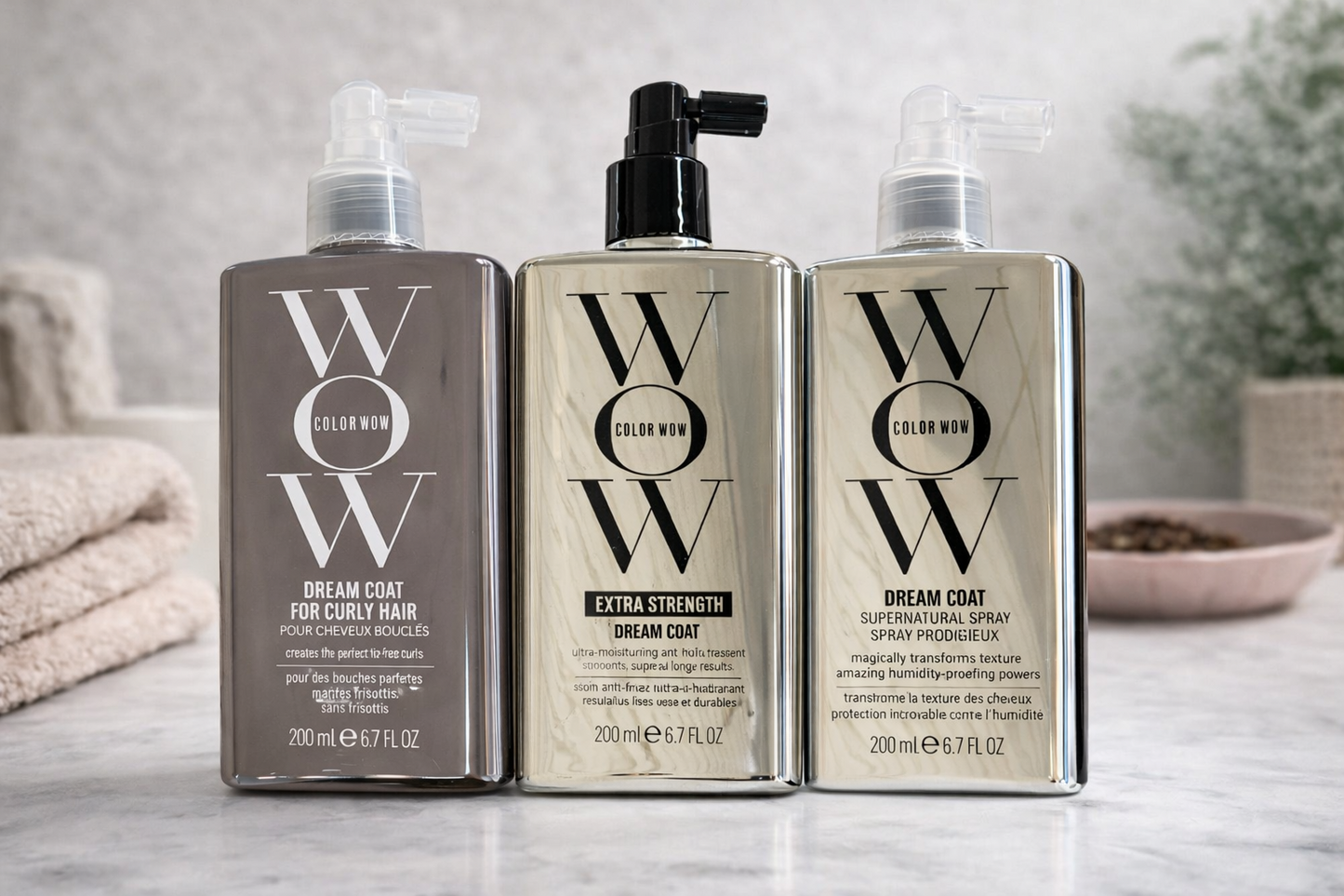 Color Wow Dream Coat Produkte nebeneinander auf heller Ablage mit Handtuch und Pflegeaccessoires – Color Wow