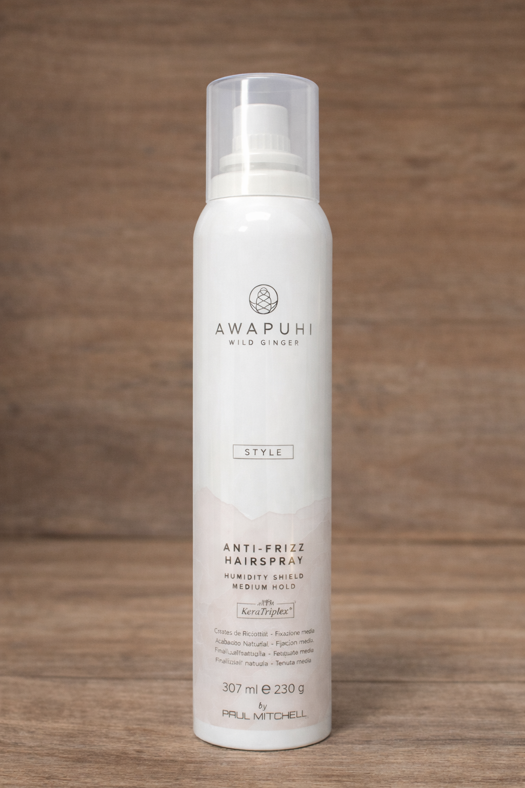 Anti Frizz Hairspray auf warmer Holzoberfläche mit natürlicher Struktur – Paul Mitchell
