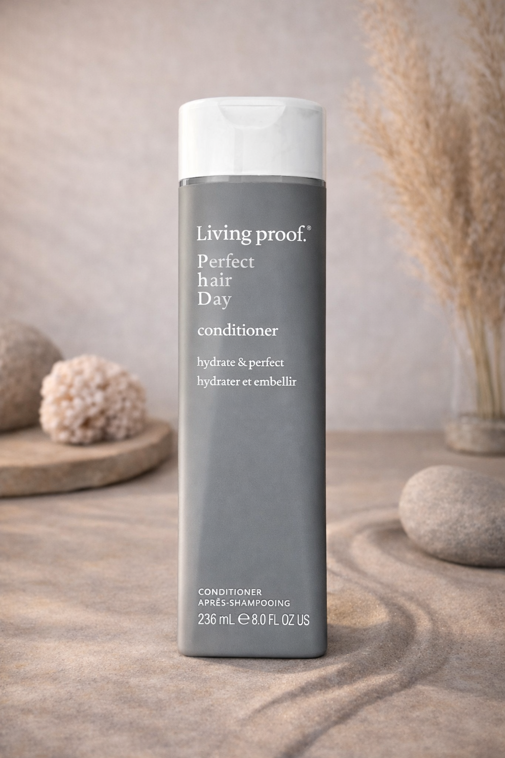 Living Proof Perfect Hair Day Conditioner auf Sandfläche mit softem Licht – Living Proof