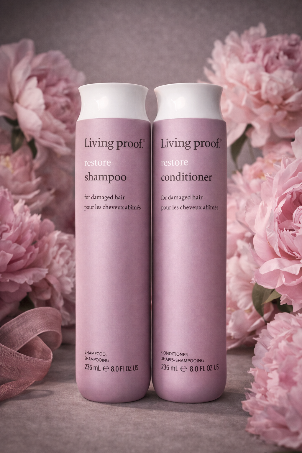 Living Proof Restore Pflegeserie nebeneinander mit dekorativem Salonhintergrund – Living Proof