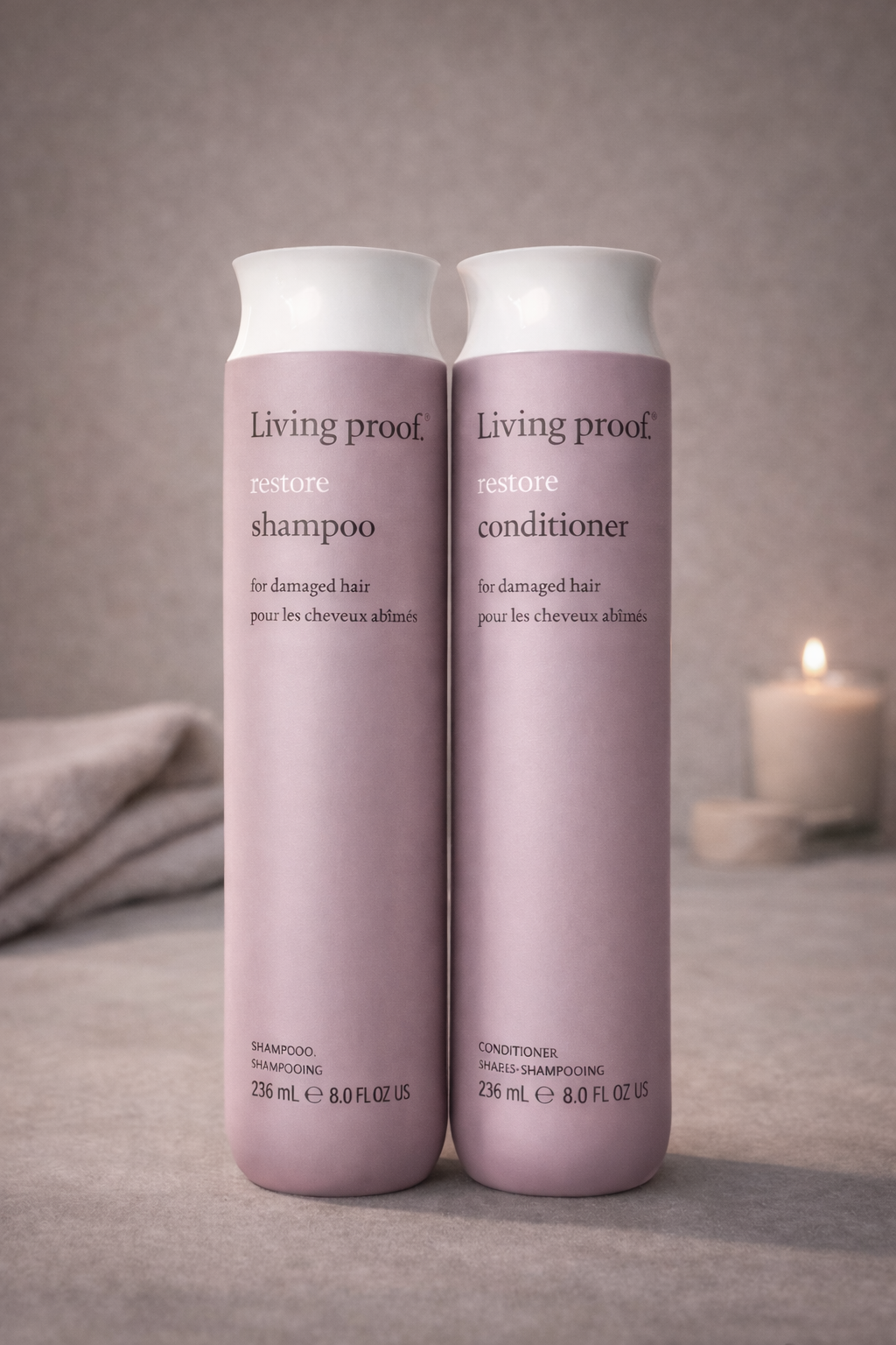 Living Proof Restore Pflegeserie nebeneinander mit dekorativem Salonhintergrund – Living Proof