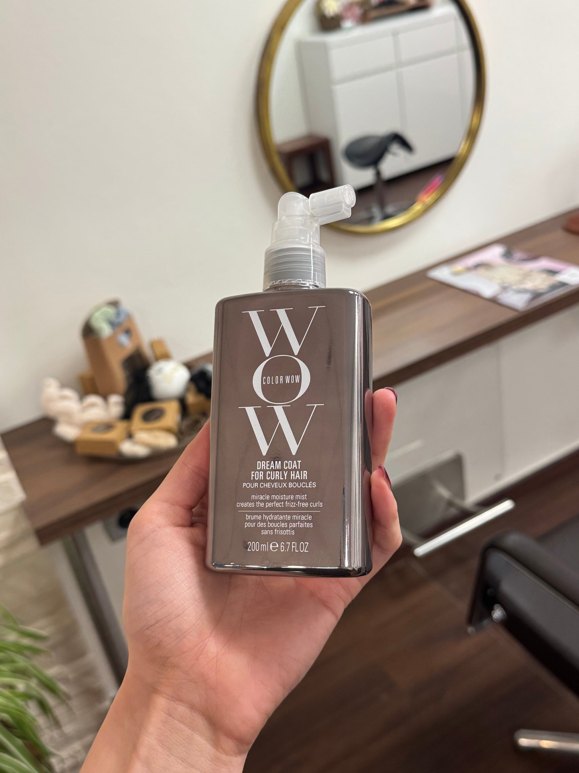 Color Wow Dream Coat for Curly Hair Lockenspray in der Hand fotografiert im Friseursalon – Color Wow