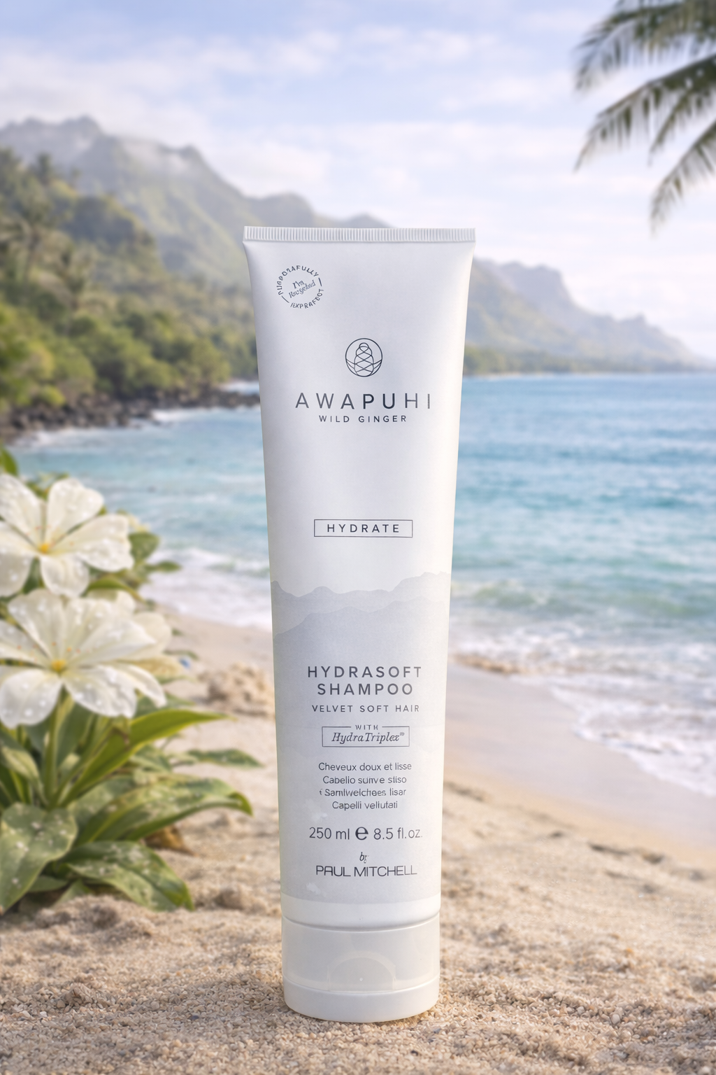 Awapuhi Hydrate Shampoo für trockenes Haar, liegend auf Sand mit weißem Ingwer als Akzent – Paul Mitchell