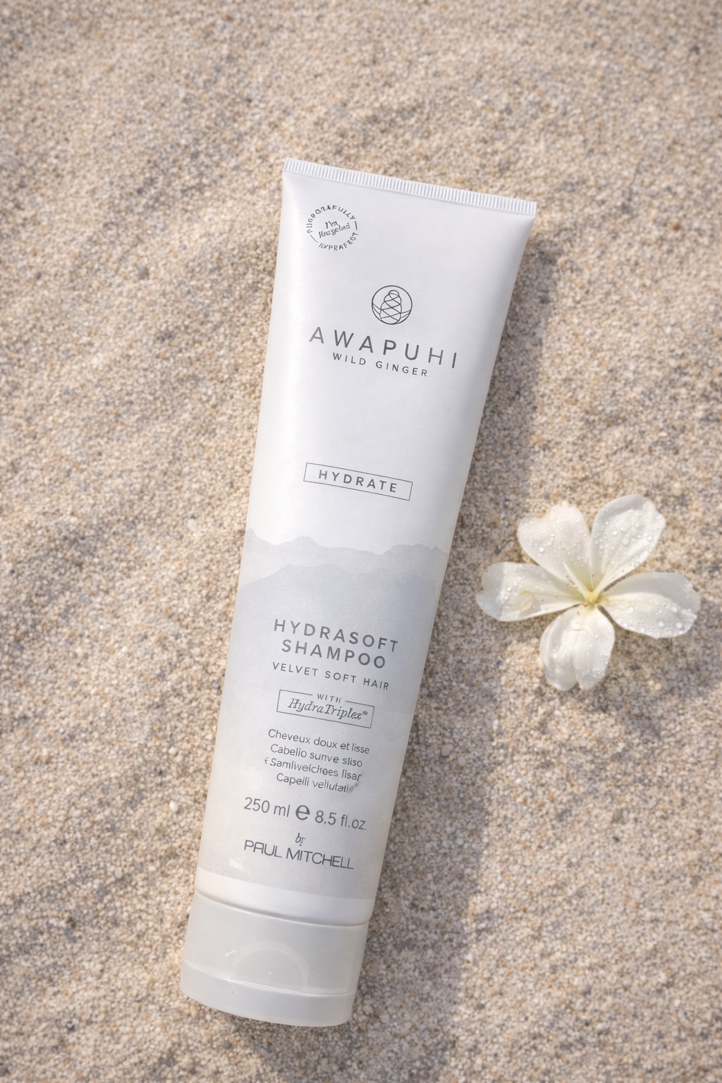 Awapuhi Hydrate Shampoo für trockenes Haar, liegend auf Sand mit weißem Ingwer als Akzent Bild zwei – Paul Mitchell 