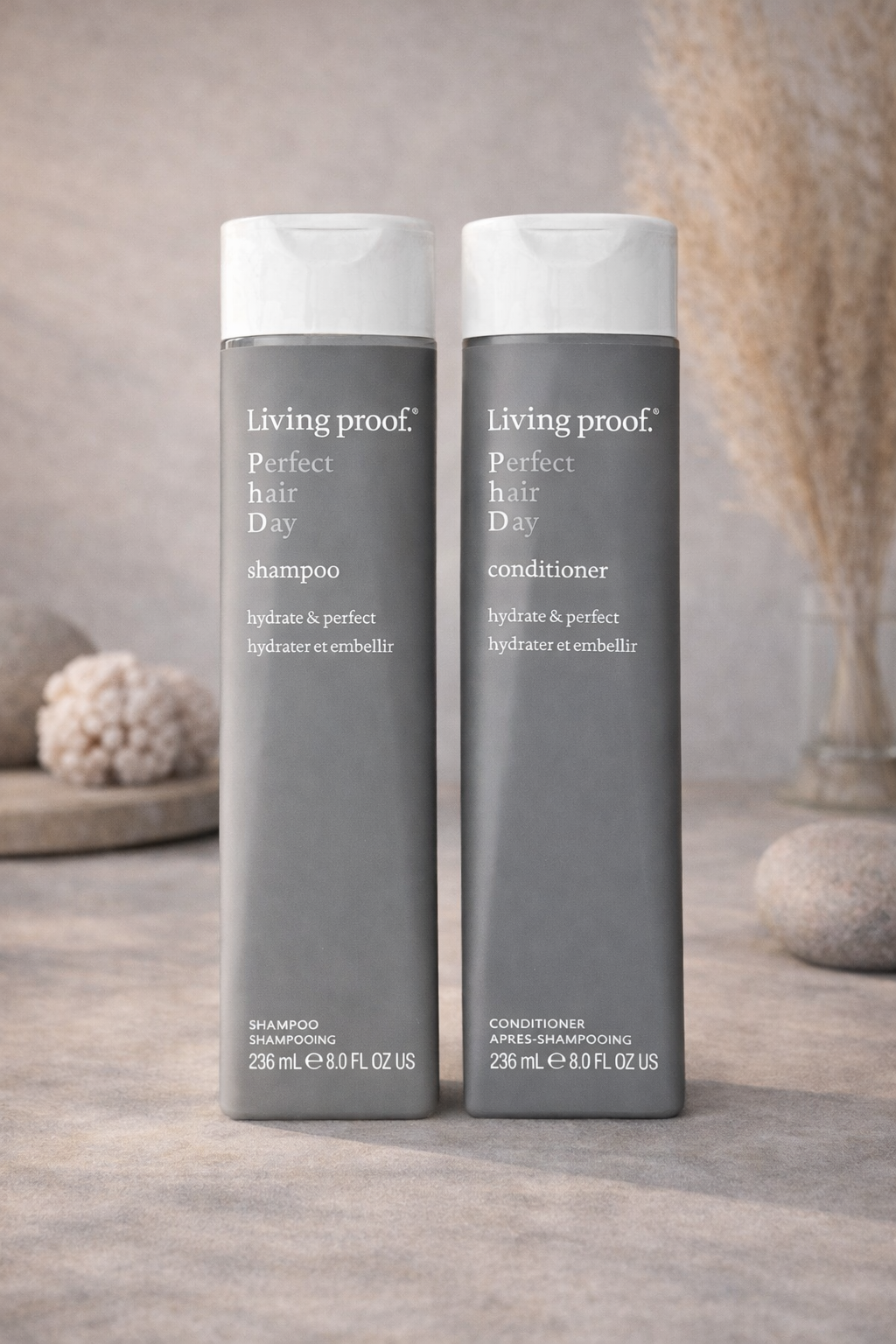Living Proof Perfect Hair Day Shampoo und conditoner auf warmem dekorativer Hintergrund mit ruhiger Lichtstimmung – Living Proof
