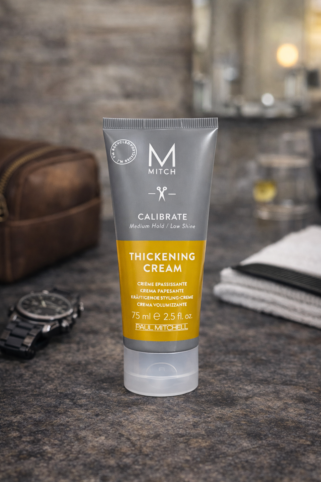 Mitch Calibrate Thickening Cream auf dunkler Steinoberfläche mit Männerpflege Zubehör – Paul Mitchell